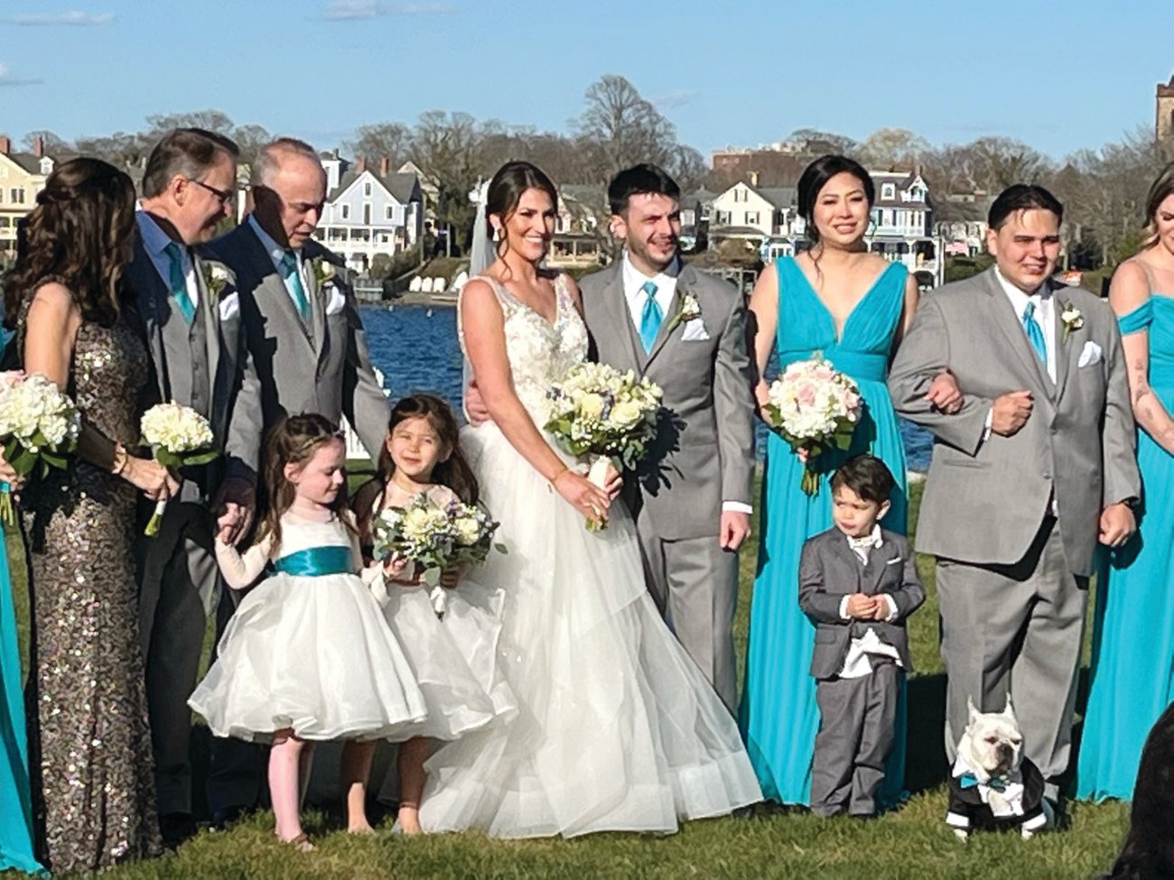 Caitlin and Bryan Schnell gather with their parents, wedding attendants, and their French bulldog, Calvin, at Gurney’s Newport Resort on Goat Island.